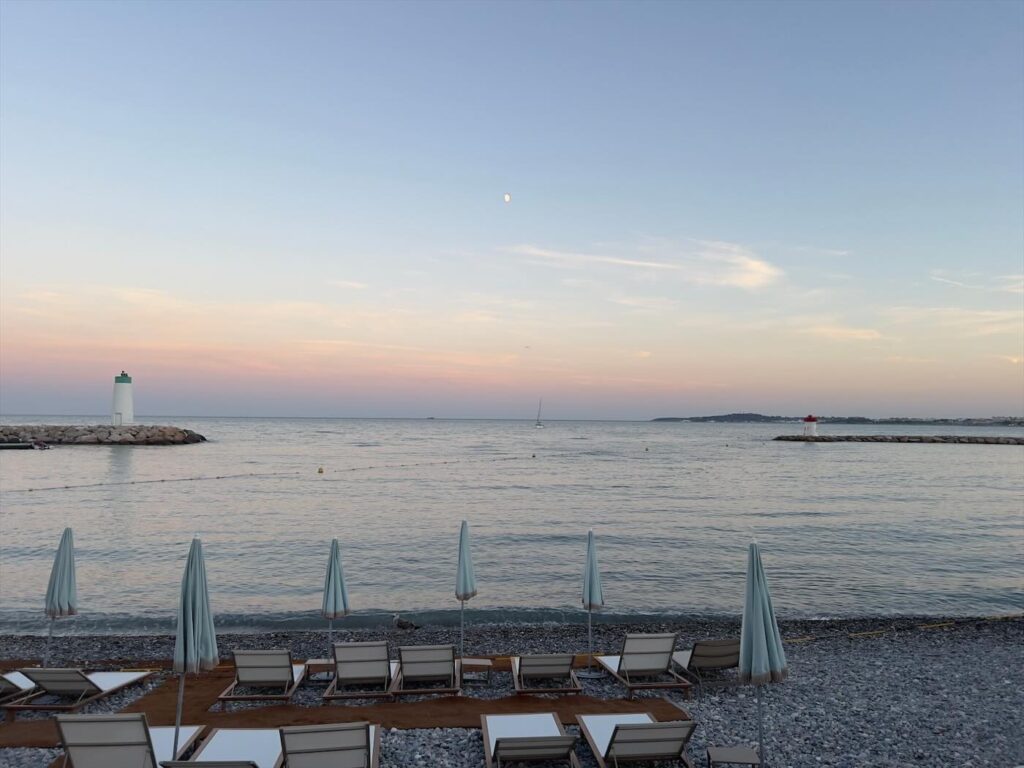 Plage privée de l'hôtel Marina Baie des Anges au coucher du soleil, entre les deux phares