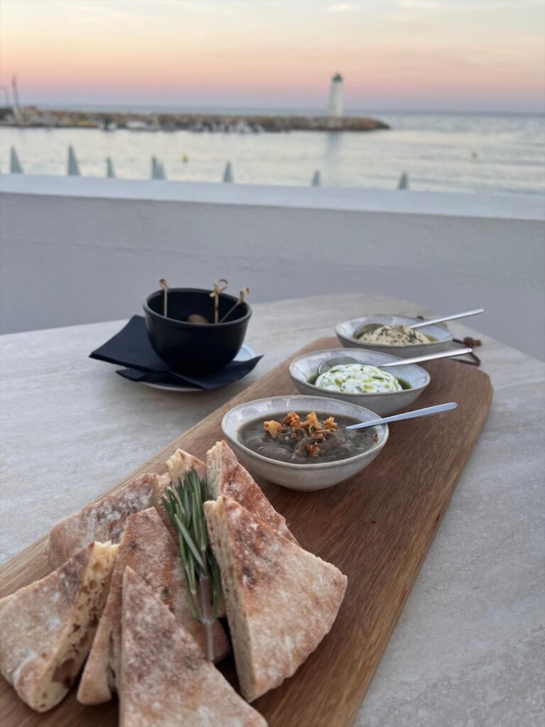 Planche apéritive avec pain et tartinades, vue sur le phare