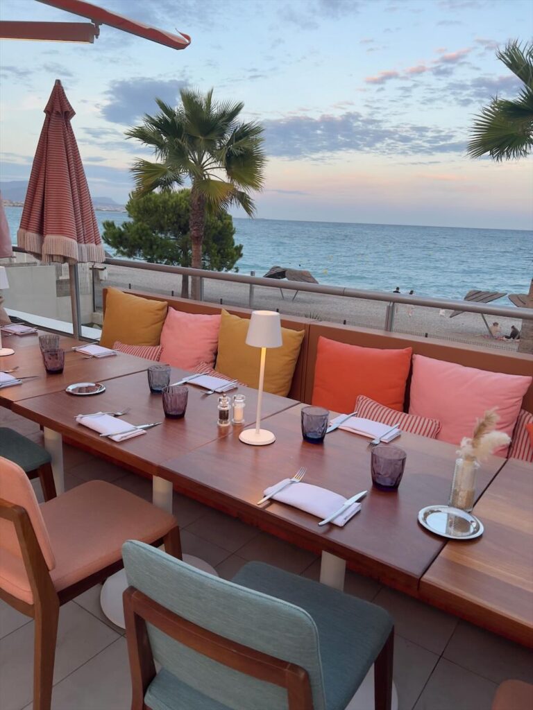 Tables dressées sur la terrasse vue mer de l'hôtel Marina Baie des Anges