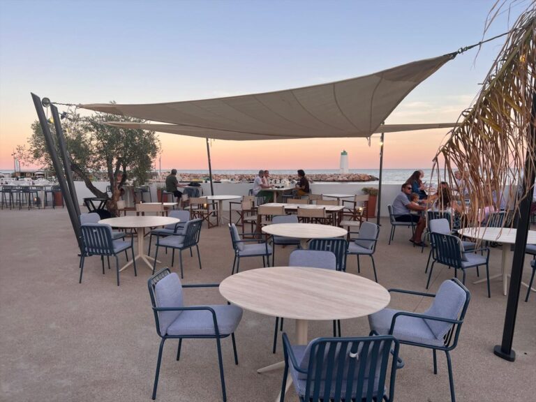 Terrasse du bar au coucher du soleil, face au phare de la marina